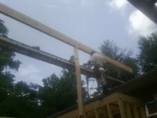 Carpenter setting a ridge beam over a new addition frame — Ice Dam Removal by Roofing Brothers in Bushnell
