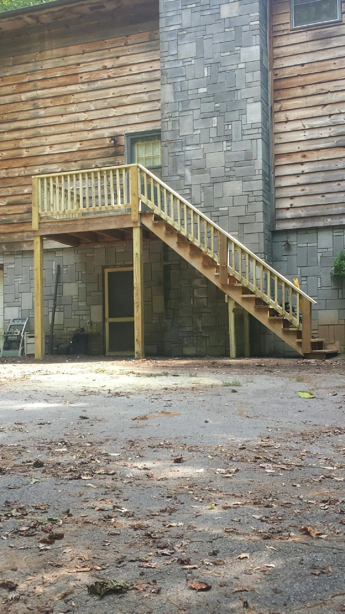 New pressure treated deck and stair landing on a log home in Bushnell